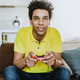 man playing video game on couch with beer